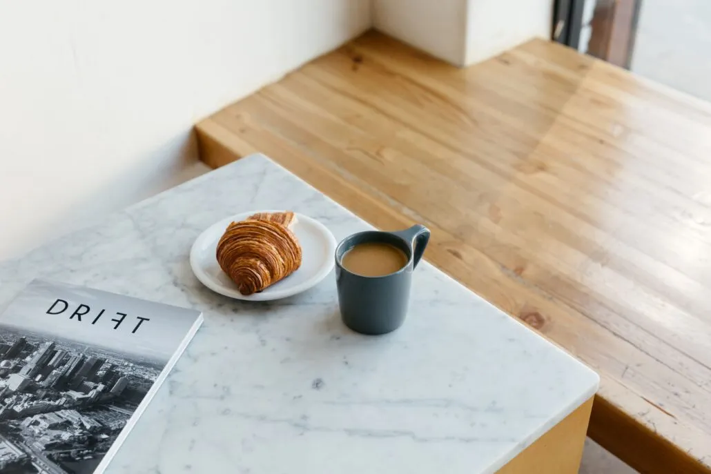 Black notNeutral Lino coffee mug beside a croissant on a table