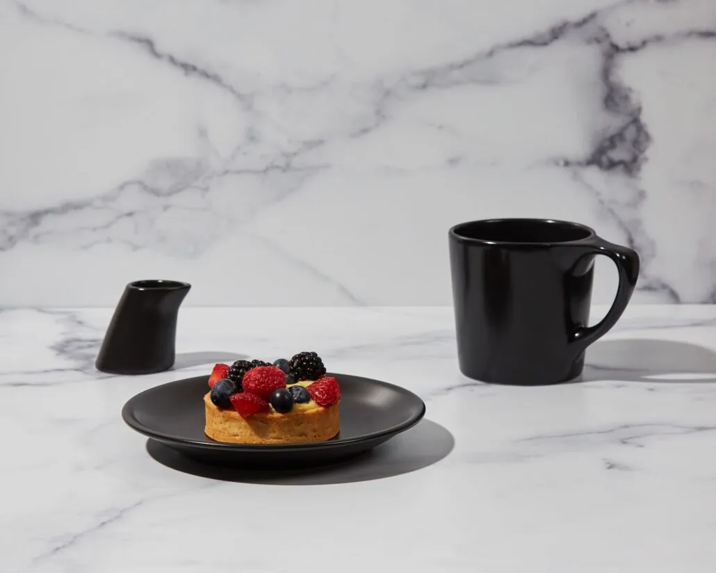Black notNeutral Lino coffee mug beside a dessert topped with berries