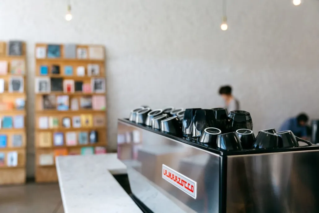 Espresso machine on a café counter with coffee equipment in the background